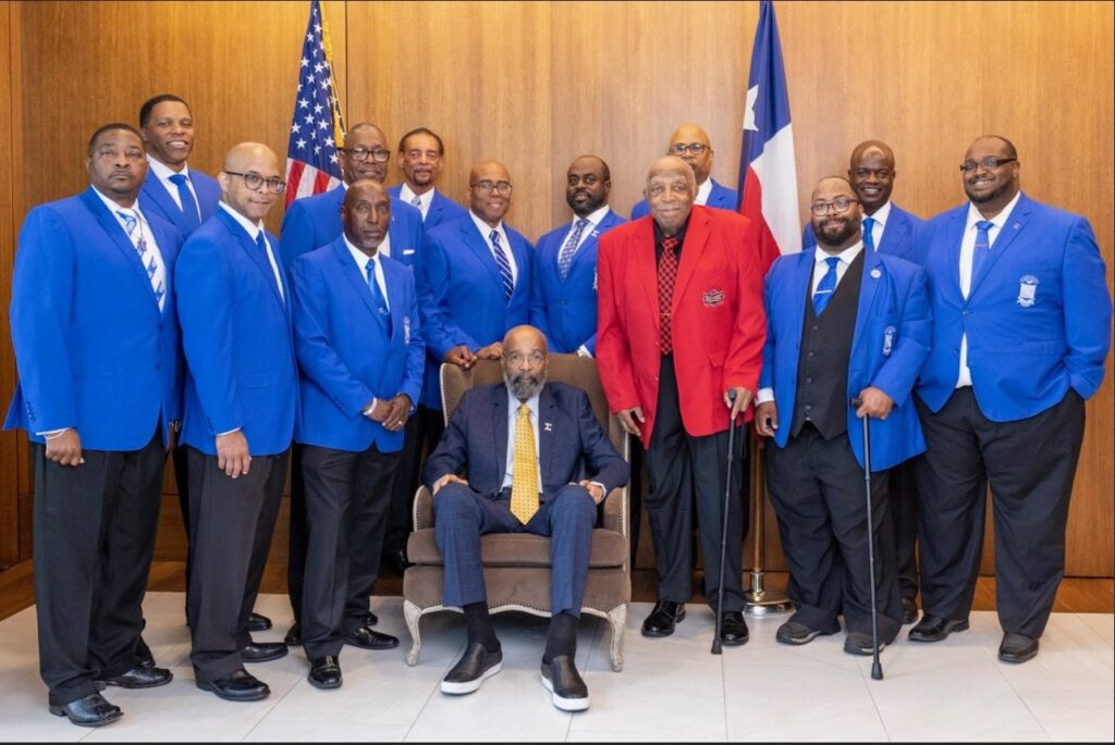 Dr. Paige with a group of men in matching blue blazers.