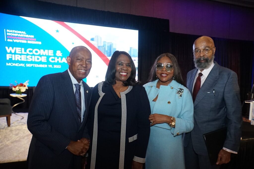 Dr. Paige with a group at a podium event.