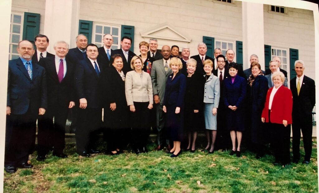 Dr. Paige with a large group at a formal gathering.