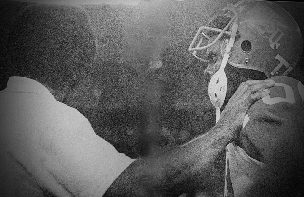 Close-up of Dr. Paige in a cap during a game.