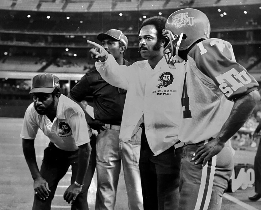 A coach on the sideline at a football stadium.