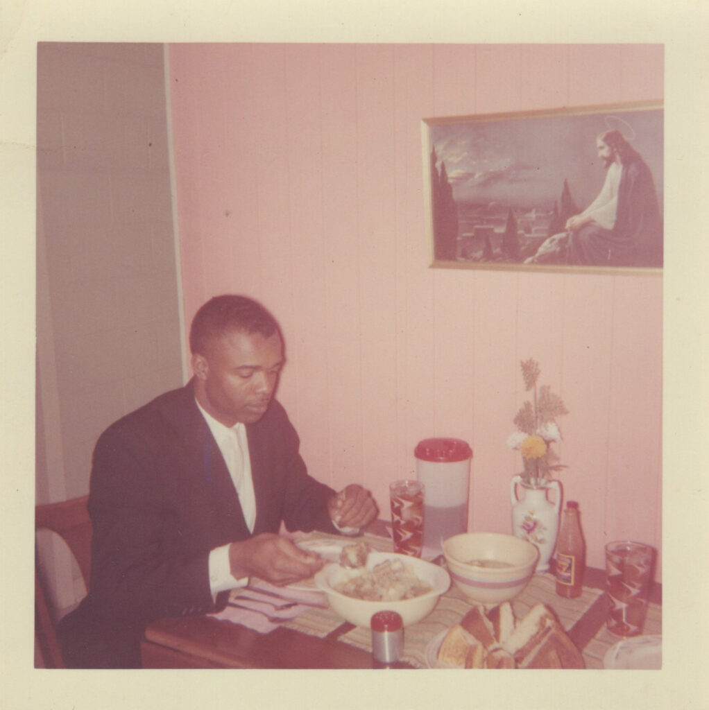 A man seated at a table indoors.